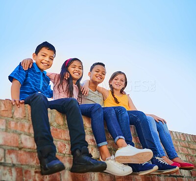 Buy stock photo Happy, friends and portrait of kids on brick wall for playing, bonding and fun together outdoors. Youth, diversity and young boys and girls hug for childhood, adventure and relaxing on weekend