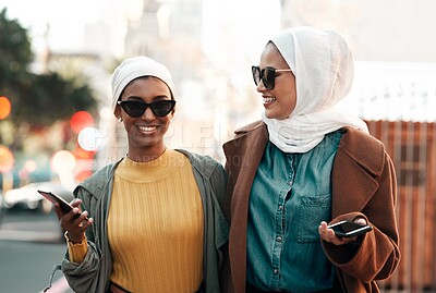 Buy stock photo Muslim women, smile and together in city for vacation, friends shopping for fashion with phone. Islam people, smile and urban holiday with sunglasses on street, wellness with mobile for travel