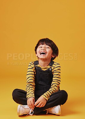 Buy stock photo Laughing, portrait and smile of Asian boy on yellow background, isolated in studio for child development. Comedy, funny or silly and excited kid on mockup space for emotions, fashion or growth