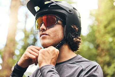 Buy stock photo Fitness, helmet and man cycling in nature on his bicycle outdoors for exercise, training and workout in spring. Sports person riding a bike and fixing headgear on an adventure in the forest or woods