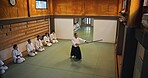 Dojo, master and demonstration of Aikido training in class with wood sword Japanese martial arts and fight exercise in studio. Learning, sport and bamboo weapon with people and strike practice above