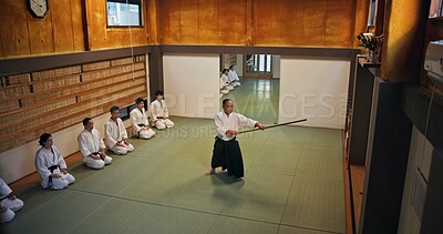 Buy stock photo Dojo, master and demonstration of Aikido training in class with wood sword Japanese martial arts and fight exercise in studio. Learning, sport and bamboo weapon with people and strike practice above