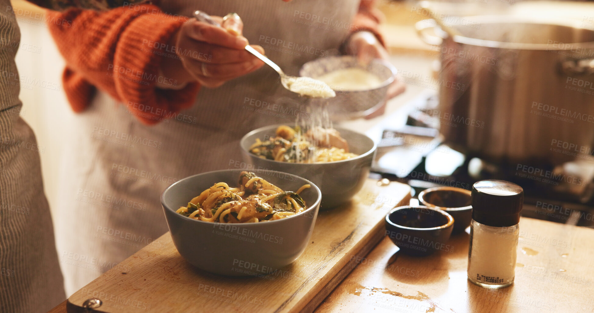 Buy stock photo Hands, home and couple with pasta, cooking and process with nutrition, organic dinner and wellness. Closeup, ceramic bowls and people in kitchen, healthy meal and serve with cheese and Italian food