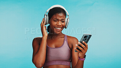 Buy stock photo Studio, black woman and music with phone for fitness, hip hop and confidence with audio track. Mockup space, female person or happy with mobile for workout song, sound or headphone by blue background