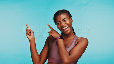 Buy stock photo Black woman, fitness and smile in studio with pointing, sports announcement or happy with space. Personal trainer, portrait or showing gesture on blue background for gym sign up promo or membership