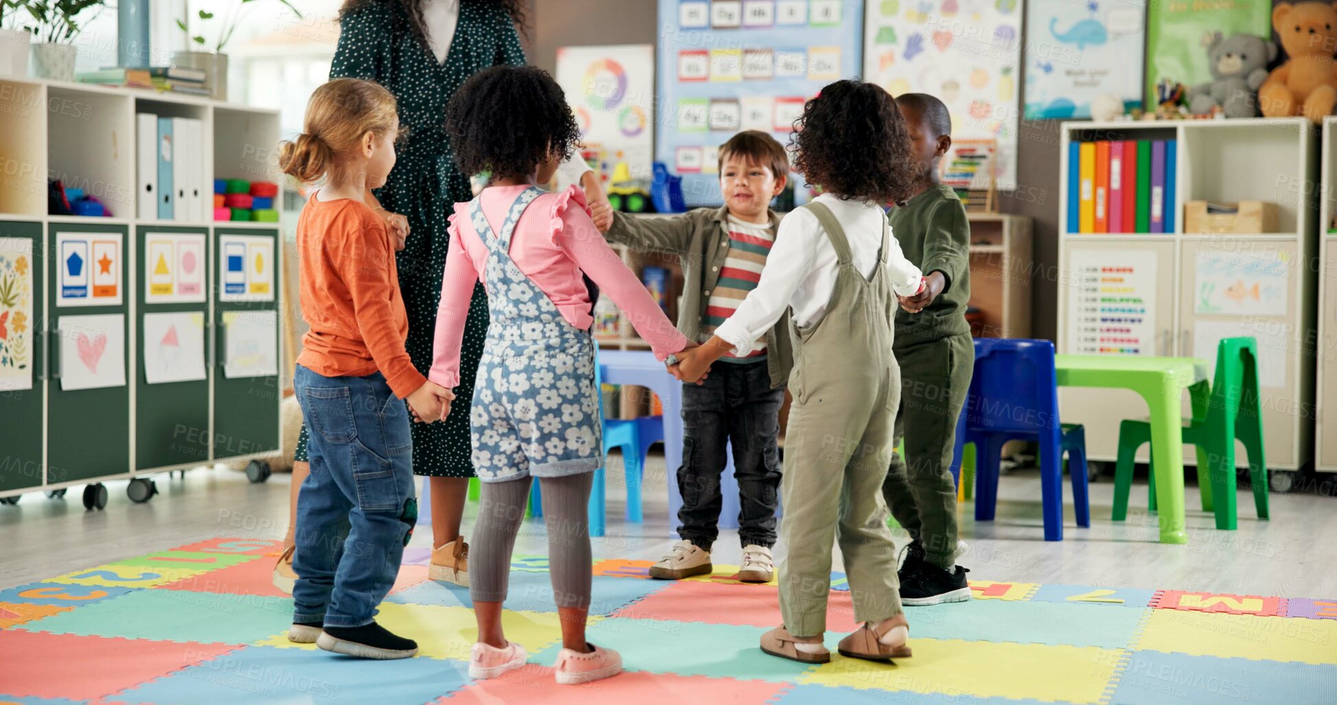 Buy stock photo Group, children and holding hands with teacher in circle for playing, game and fun activity at recess. Montessori, kids and learning break for classroom community, motor skills and growth development