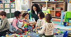 Building blocks, education and teacher with children in classroom for learning, playful or creative games. Growth, kindergarten or academy with woman and kids at school for toys and child development