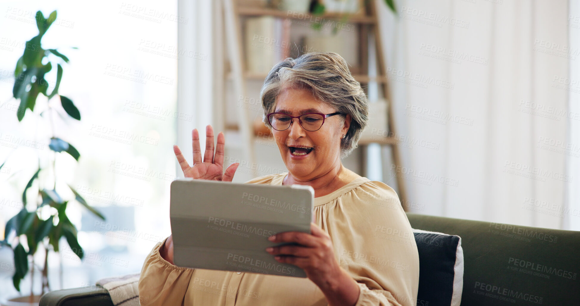 Buy stock photo Senior woman, wave and video call on tablet on sofa in house living room for fun conversation. Smile, greeting and elderly person speaking online for retirement, connection and virtual chat together