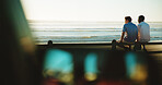 Men, back and friends at beach for break with bonding, space and support outdoor. Sunset, people and happy on wood fence, travel or vacation to relax with connection in nature with ocean view