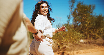 Buy stock photo Happy woman, walking or holding hands with partner for travel, journey or outdoor trip together in forest. Female person, couple or lovers with help, support or trust for safety or security in woods