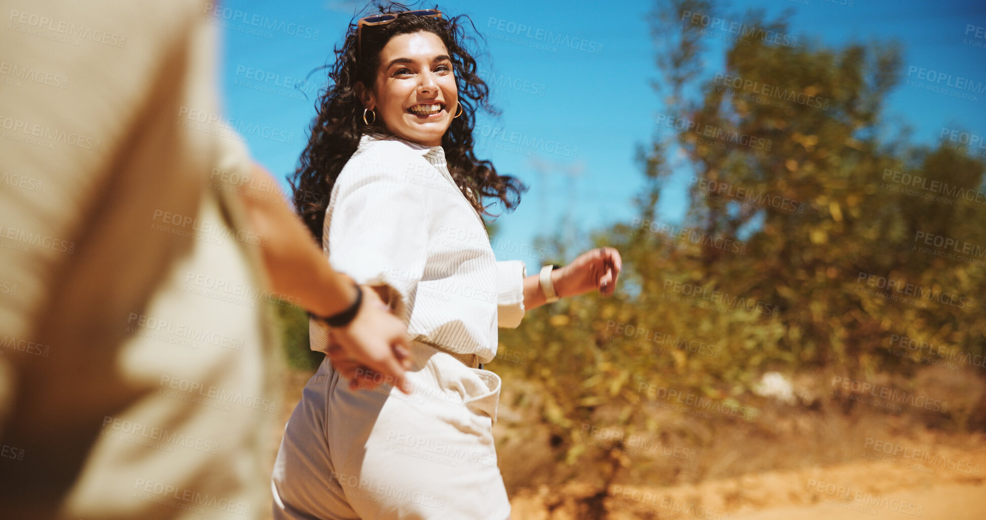 Buy stock photo Happy woman, walking or holding hands with partner for travel, journey or outdoor trip together in forest. Female person, couple or lovers with help, support or trust for safety or security in woods