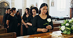 Woman, rose and coffin at funeral for farewell service, mourning death and goodbye at burial ceremony. Person, flower and respect for rip, memorial comfort and emotional gathering at community church