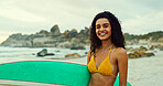 Woman, surfer and happy in portrait at beach for water sports, hobby and outdoor on holiday. Girl, surfboard and smile with equipment for training, fitness and ready for waves by ocean in Brazil