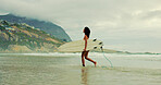 Girl, surfboard and walk at beach with waves for water sports, hobby and outdoor in morning on holiday. Woman, surfer and happy for training, fitness and profile for exercise by ocean in Costa Rica