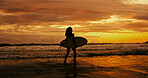 Silhouette, sunset and person with surfboard, water and adventure for surfer on holiday, back and beach. Summer vacation, travel and woman with fitness for sport, evening and hobby in nature or ocean