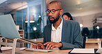 African man, computer and typing at office, night and editing proposal with overtime at media company. Person, editor and writer by pc with glasses for deadline, project or time management at agency