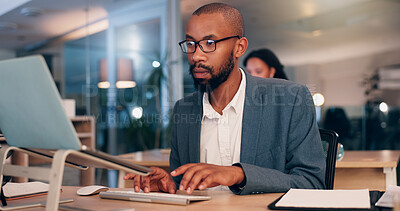 Buy stock photo African man, computer and typing at office, night and editing proposal with overtime at media company. Person, editor and writer by pc with glasses for deadline, project or time management at agency