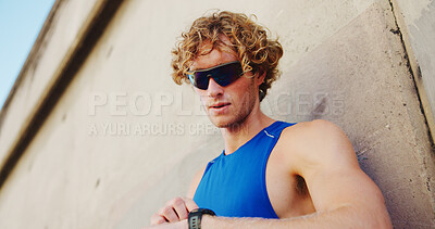 Buy stock photo Fitness, man and smart watch at wall for time, tracking progress and cardio assessment in app. Runner, below and tech in city for stopwatch, challenge update and training notification at space