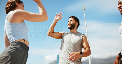 Buy stock photo Fitness, people and high five in city for achievement, team support and wellness goal. Low angle, man and woman outdoor with hand gesture, motivation and personal trainer in session with commitment