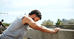 Fitness, tired and man on break in city with fatigue, exhausted and relax for exercise recovery. Workout, rest and athlete outdoor for wellness, body health or think of training challenge on bridge