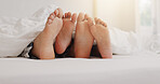 People, feet and relax in bed with love, lazy weekend and romantic getaway in hotel. Couple, toes and sleeping in resort bedroom with touch, comfort or relationship development with trust in marriage