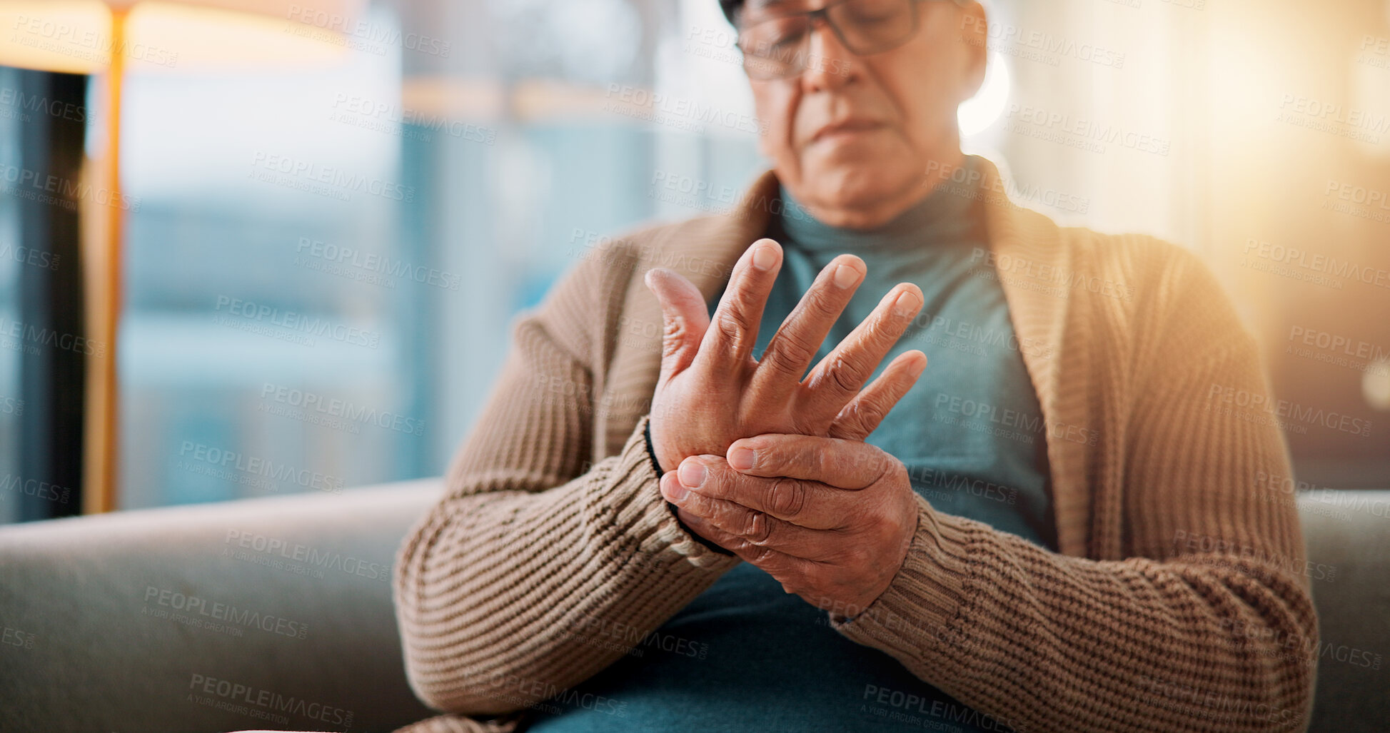 Buy stock photo Hands, home and old man on sofa, pain and inflammation with arthritis in living room. Muscle tension, pensioner and elderly person on couch, osteoporosis and parkinson disease with fibromyalgia