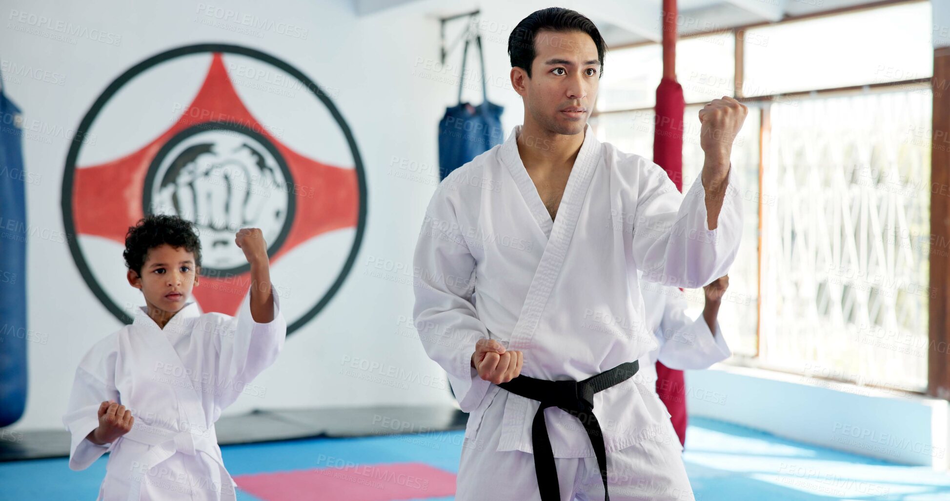 Buy stock photo Sensei, lesson and man with kids in karate class, self defense training or martial arts with youth for combat education. Taekwondo, fight and male instructor with student children coaching in dojo