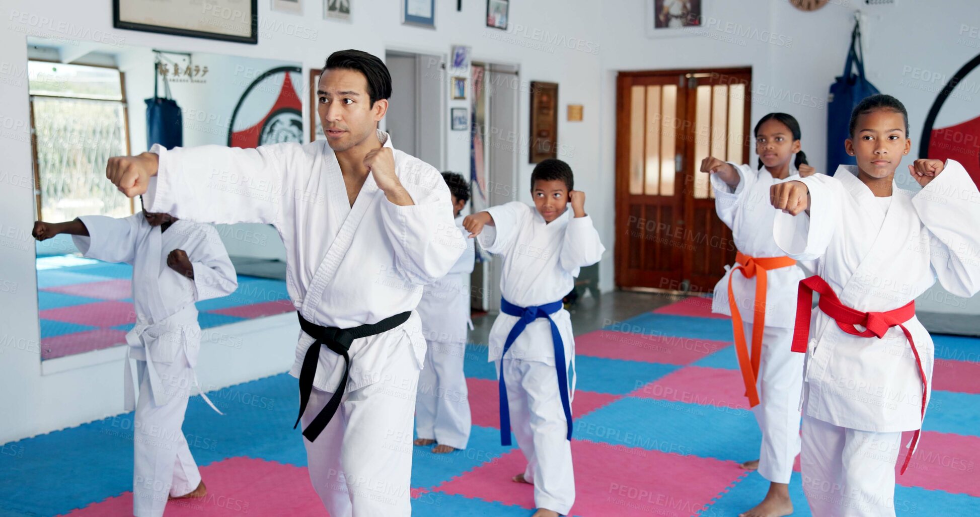 Buy stock photo Sensei, punch and man with children in karate class, self defense training or martial arts for youth for combat education. Taekwondo, fight and male instructor with student kids for coaching in dojo