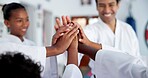 Kids, teacher and hands together in dojo for martial arts training, self defense or fighting competition. Children, motivation and celebration with support for taekwondo challenge or community karate