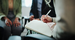 Counseling, hands or writing with book in group meeting for support, therapy session or report at office. People, hr or taking notes with team for mental health, feedback or intervention at workplace