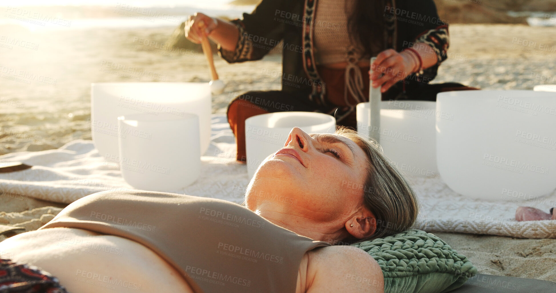 Buy stock photo Meditation, sound therapy and women with bowls at beach for mindfulness, spiritual cleanse and energy. Nature, morning ritual and person with frequency for healing, balance and wellness by ocean