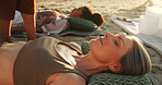 Women, crystal and energy at beach with chakra balance, therapy and healing with rest on vacation. People, stone and holistic care with mineral, mindfulness and shaman with zen on ground in summer