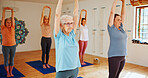 Senior women, stretching and yoga class with group for holistic training, mindfulness or wellness. Elderly, female people or yogi with arms up in pilates for workout, exercise or fitness in studio