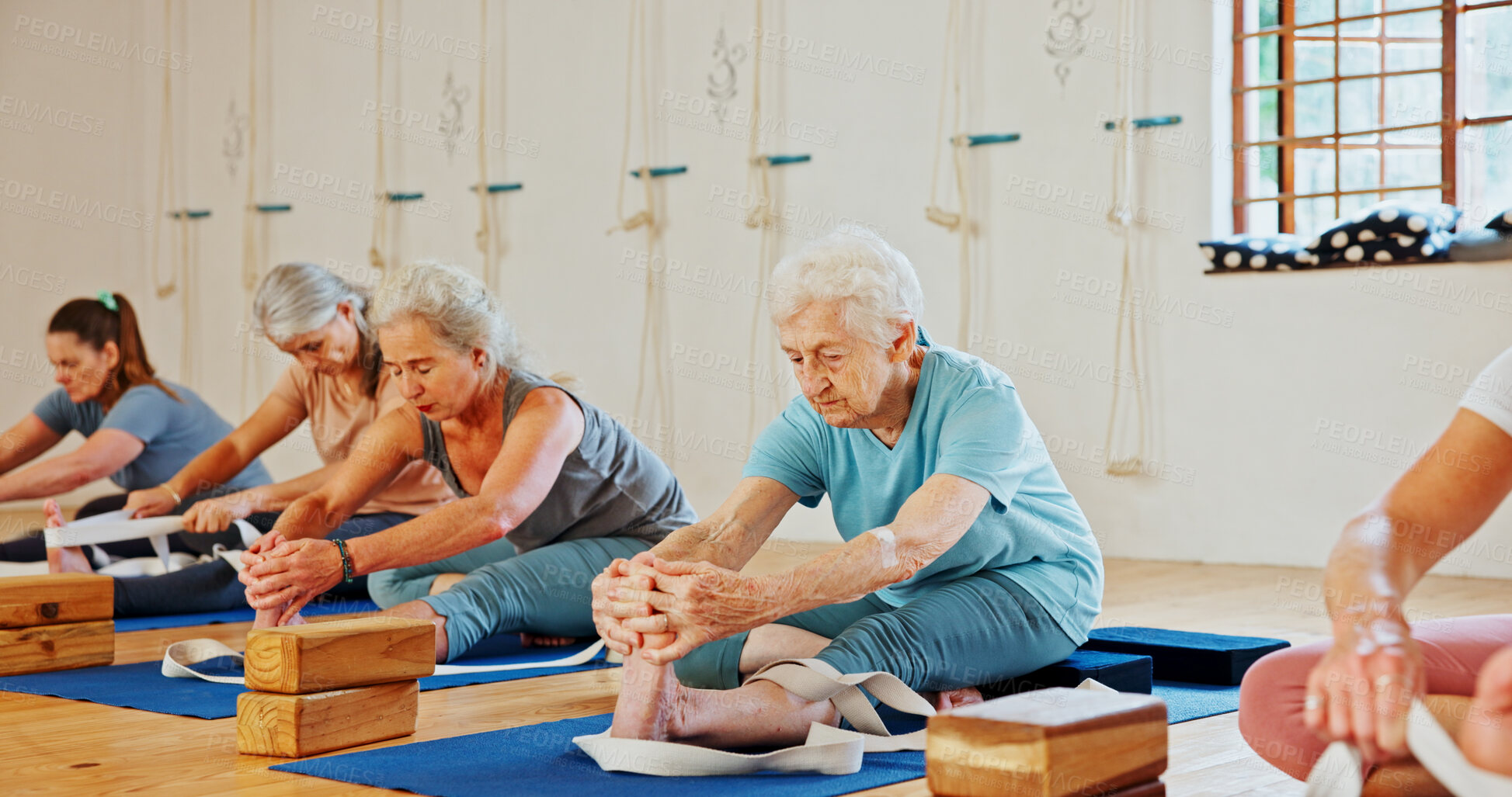Buy stock photo Elderly, people and stretching with band for yoga class, flexibility and spiritual wellness. Senior women, muscle warm up and community pilates, holistic practice and mobility exercise at health club