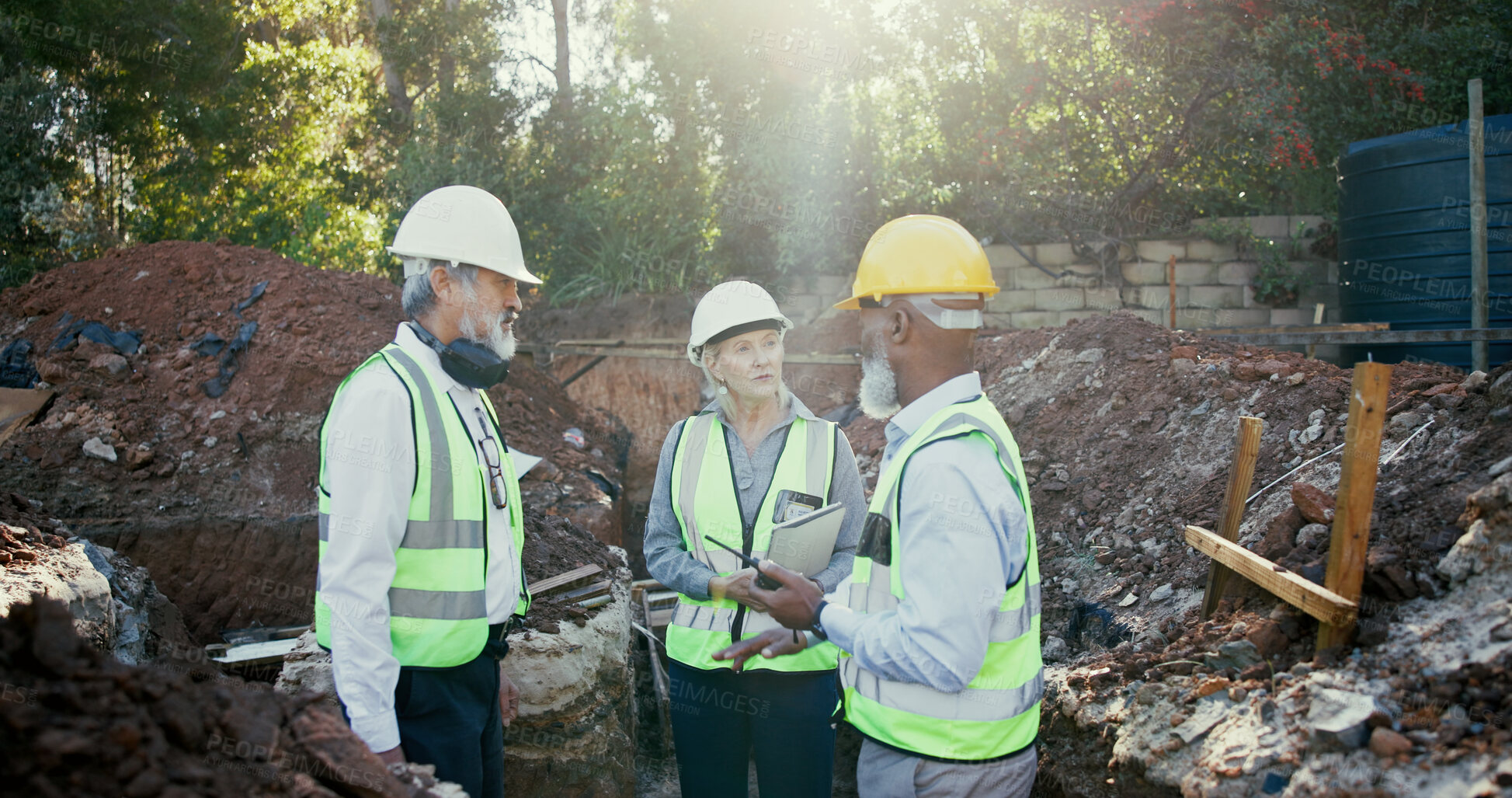 Buy stock photo Engineering, people and meeting on construction site with radio, discussion and update with tablet. Woman inspector, mature team and tech in worksite foundation with contact for project management