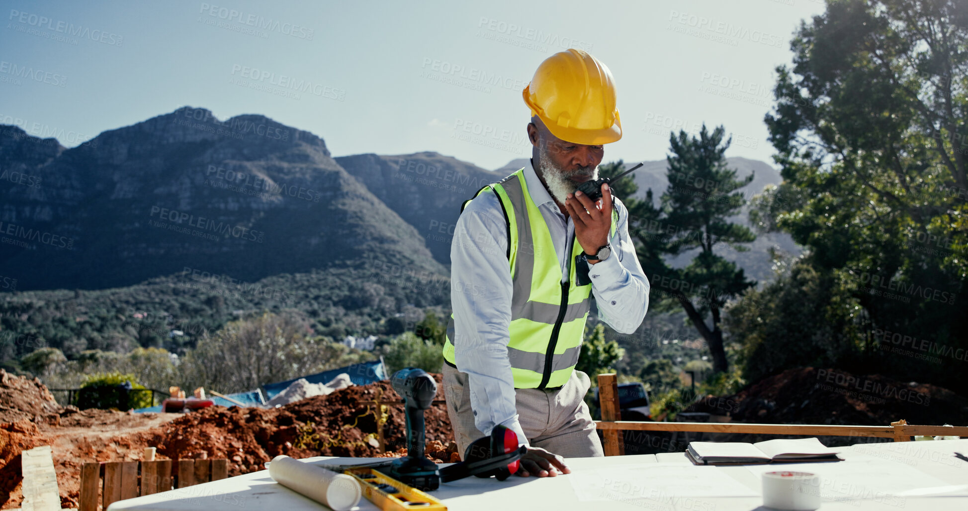 Buy stock photo Radio, communication or black man with blueprint for engineering, check design and construction site. Mature architect, outdoor and talking on worksite for brainstorming, compliance and floor plan