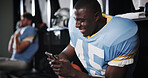 Football, player and happy with phone in locker room for funny text message, social media meme or match break. Sports, man or relax with smartphone for online news, mobile chat or internet connection