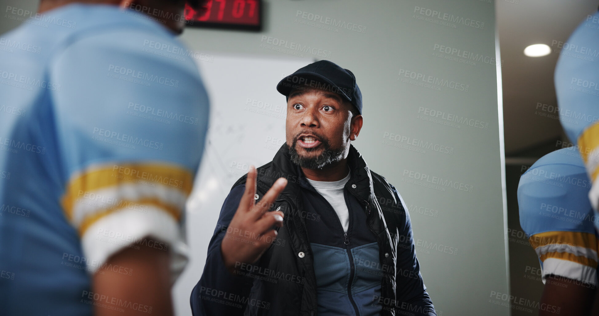 Buy stock photo Talking, match and football with coach and team in locker room for game plan, sports strategy or defense formation. Touchdown tactics, half time feedback and discussion with people and advice