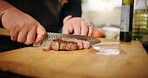 Kitchen, hands or man with steak, cutting or culinary skills with food, knife or healthy ingredients. Person, closeup or chef with wood board, home or beef cuisine with recipe, nutrition or meal prep