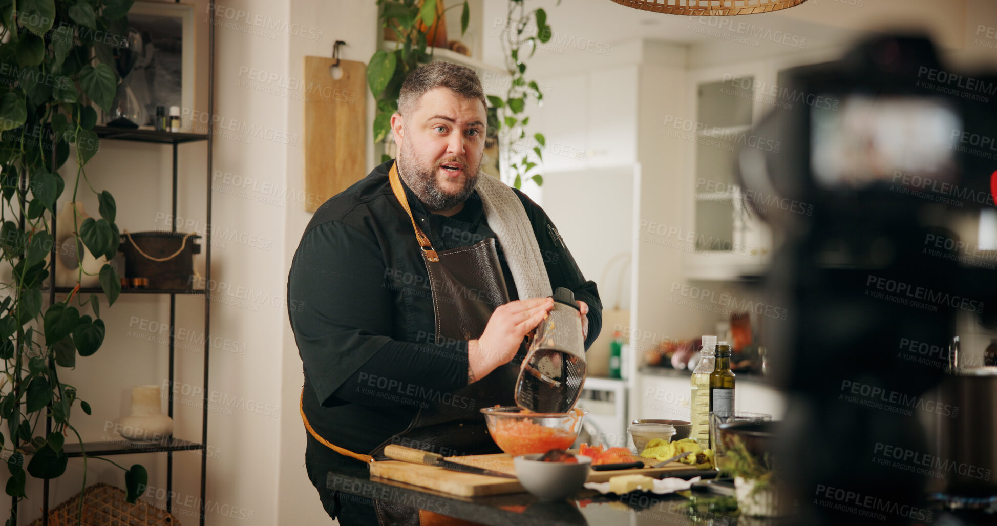 Buy stock photo Ingredients, cooking and man with live streaming in kitchen for dinner recipe, meal prep or video recording. Culinary influencer, content creation or person with cuisine tutorial or nutrition in home