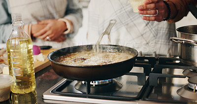 Buy stock photo People, hands and cooking food in kitchen with recipe, add seasoning and meal preparation. Couple, dinner and pan on stove for simmering, nutrition and bonding in home with cuisine for wellness