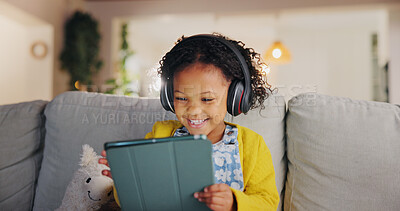 Buy stock photo Tablet, headphones and happy child on sofa for music, online learning and play game for education. Girl, audio and kid with tech in home living room for internet app, streaming cartoon or watch video