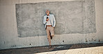 Business, funny and man with smartphone, wall and smile with connection, meme and texting. Mature person, outdoor and employee in city, cellphone and digital app for online comedy, humor and joke