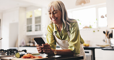 Buy stock photo Cooking, phone and smile of woman in kitchen to search for ingredients or instructions of recipe. App, food and social media with happy senior person in apartment for diet, health or nutrition
