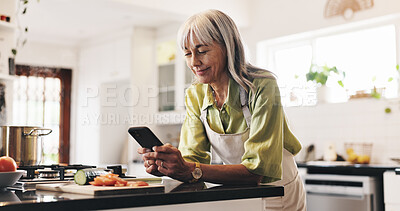 Buy stock photo Cooking, phone and reading of woman in kitchen to search for ingredients or instructions of recipe. App, food and scrolling with happy senior person in apartment for diet, health or nutrition