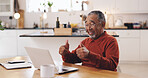 Senior man, laptop and thumbs up for video call in kitchen for tax, documents or review for pension. Elderly person, computer and sign for financial advisor with yes, deal and retirement plan in home