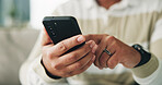 Man, hands and scroll with phone on sofa for app download, playing online game and streaming service. Closeup, relax and person with smartphone in home for social media, reading ebook or dating site