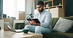 Home, man and typing on tablet for logistics, distribution and remote work for customer service. Sofa, male person and business owner with digital for ecommerce, inventory management and supply chain