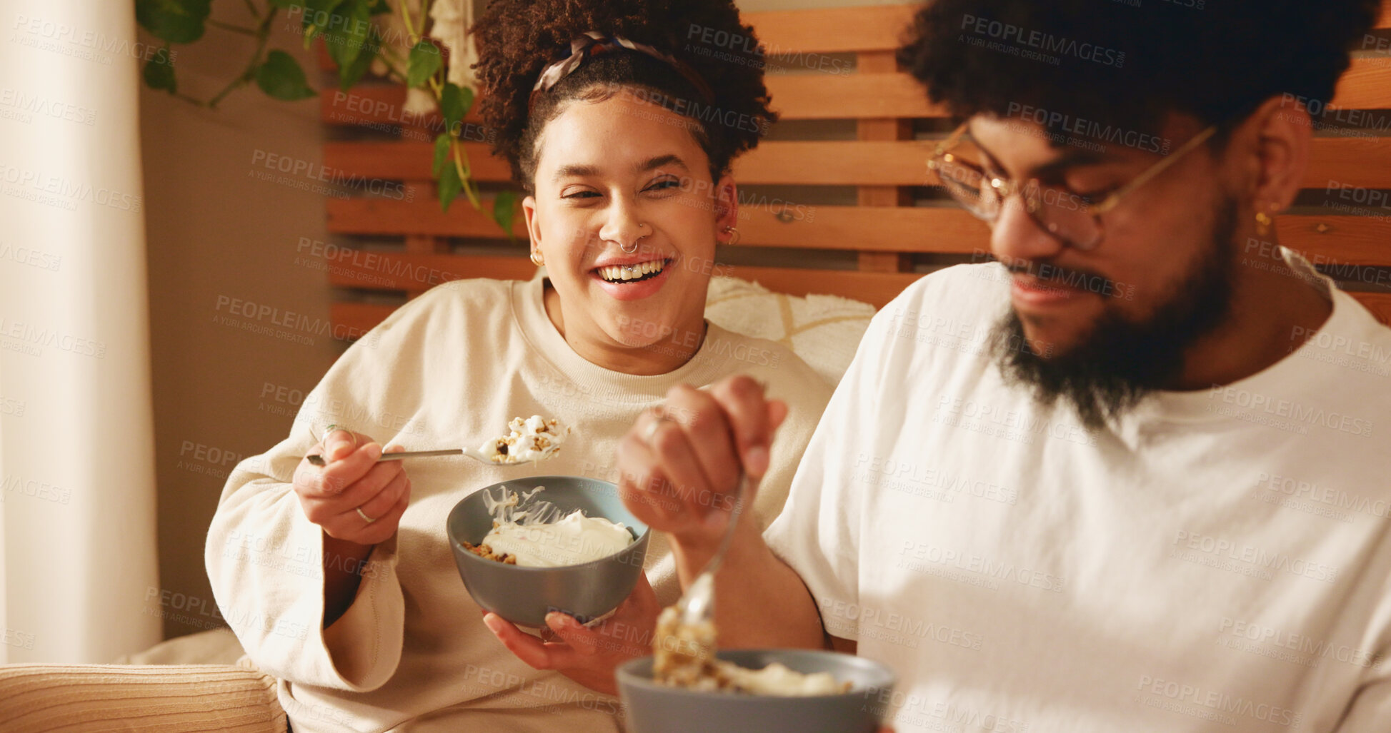 Buy stock photo Bedroom, laughing and couple with food for breakfast, nutrition and bonding with eating in morning. Home, woman and man with love for healthy meal, granola and yogurt with happiness in apartment