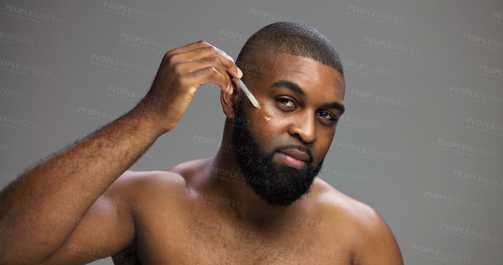 Buy stock photo Serum, beauty and portrait of black man in studio for salon, grooming and dermatology. Cosmetics, glow and self care with person and oil dropper on gray background for hydration, skincare and shine